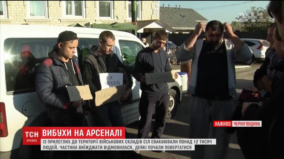 Хлопці впіймали мародерів, що грабували домівки евакуйованих людей, виставили їх на площі з надписами «Я ЗЛОДІЙ»